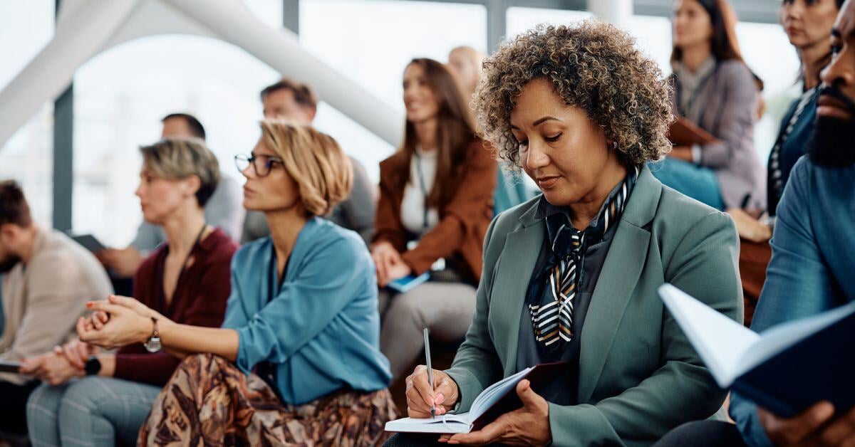 woman taking notes at lecture